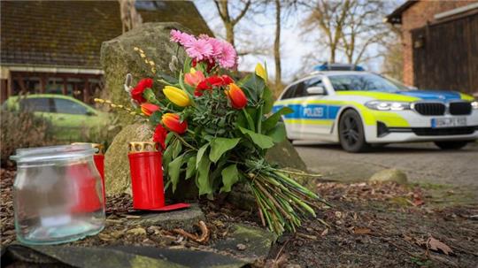 Blumen und Kerzen stehen vor einem Haus in Westervesede in der Gemeinde Scheeßel, in dem ein Mann geschossen haben soll.