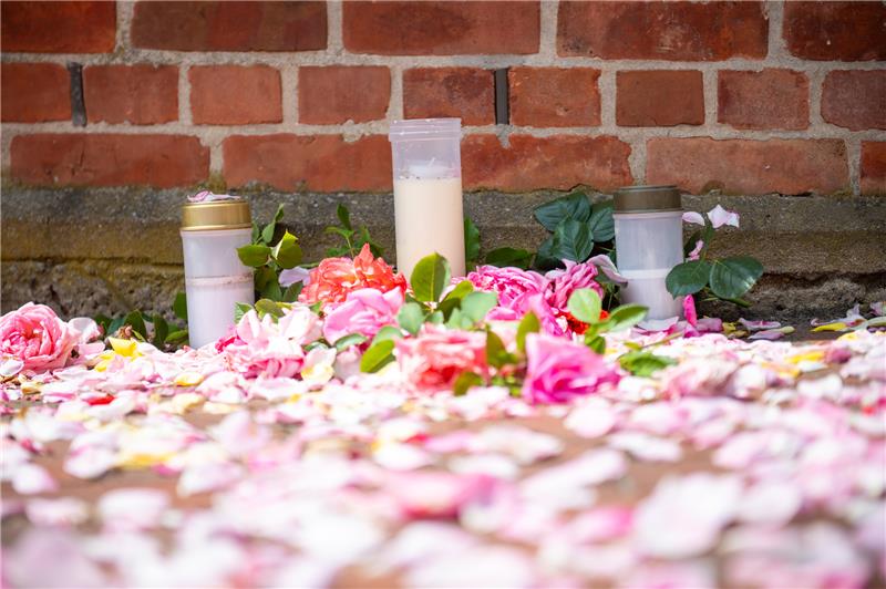 Blumen und Trauerkerzen vor dem Gebäude der Gemeindeverwaltung Toppenstedt. Foto: Jonas Walzberg/dpa