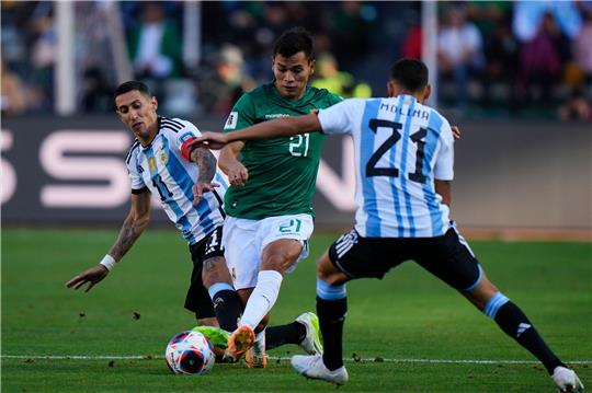 Boliviens Hector Cuellar in Aktion gegen die Argentinier Angel Di Maria (l) und Nahuel Molina (21).