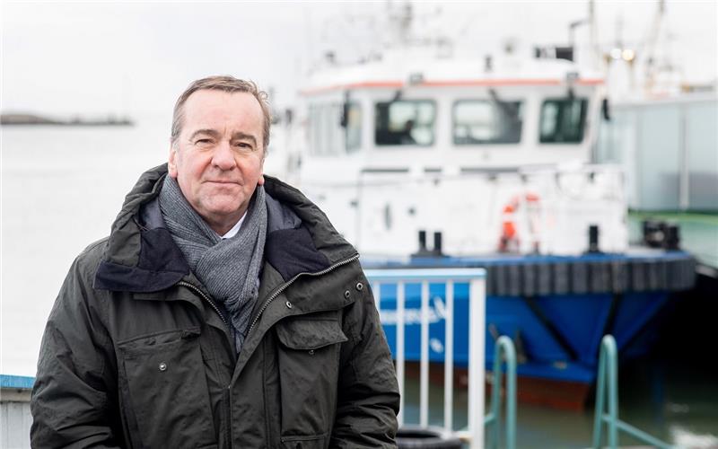 Boris Pistorius (SPD), Innenminister in Niedersachsen, steht vor einem Schiff der Wasserschutzpolizei. Innenminister Pistorius wollte sich einen Eindruck von der Arbeit der Polizistinnen und Polizisten verschaffen, die zum Schutz des im Bau befindlichen LNG-Terminals in Wilhelmshaven im Einsatz sind. Foto: Hauke-Christian Dittrich/dpa