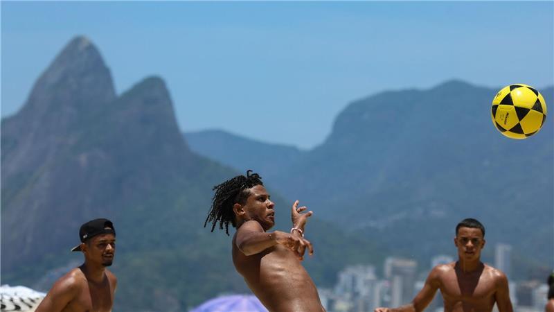 Brasilianer spielen bei 32 Grad nach den Weihnachtstagen Fußball am Strand in Rio de Janeiro.