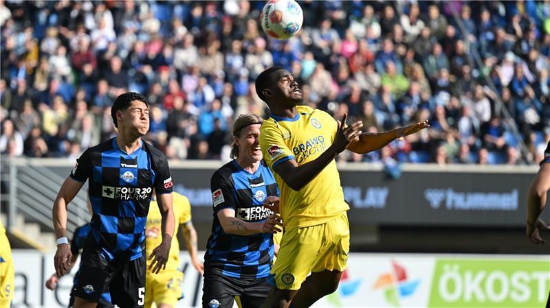 Braunschweigs Patrick Nkoa ist eher am Ball als die beiden Paderborner Santiago Castaneda (l) und Felix Götze.