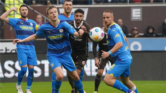 Braunschweigs Robert Ivanov (l-r), St. Paulis Elias Saad und Braunschweigs Marvin Rittmüller kämpfen um den Ball.