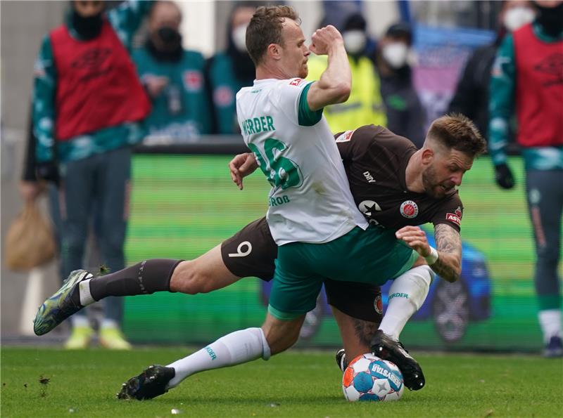 Bremens Christian Groß (vorne) und St. Paulis Guido Burgstaller kämpfen um den Ball. Foto: Marcus Brandt/dpa