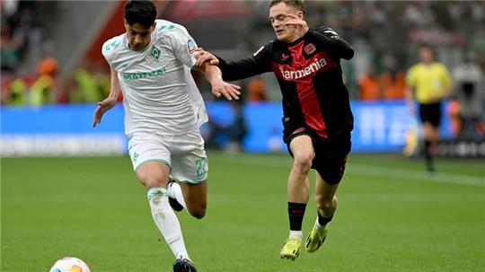 Bremens Julian Malatini (l) und Leverkusens Florian Wirtz kämpfen um den Ball. 