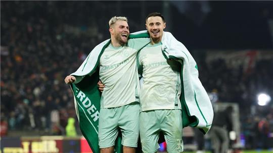 Bremens Marvin Ducksch (links) und Marco Friedl feiern mit den Fans.