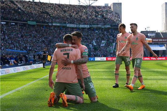 Bremens Marvin Duksch jubelt nach seinem 2:0-Treffer mit Bremens Marco Friedl. Rechts kommen Bremens Christian Gross und Mitchell Weiser (r). Foto: Soeren Stache/dpa -