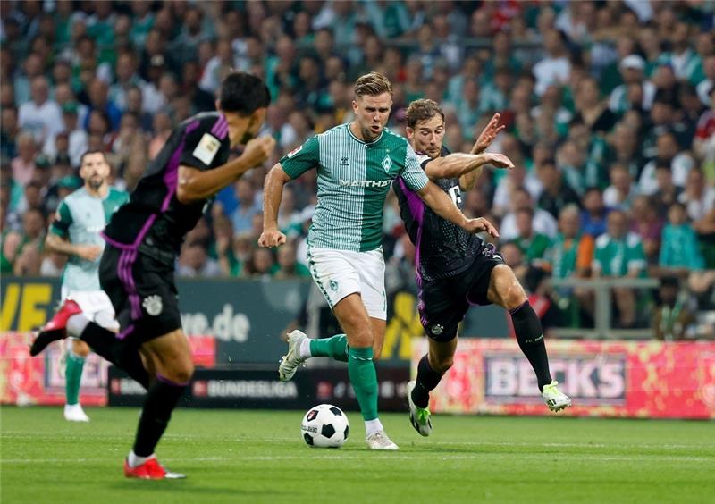 Werders Glaube an Geschlossenheit - und die Hoffnung auf neue Kräfte Bremens Niclas Füllkrug (M) und Bayerns Leon Goretzka kämpfen um den Ball. Foto: Axel Heimken/dpa