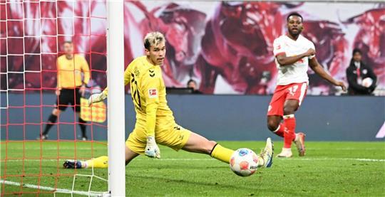 Bremens Torwart Mio Backhaus (l, Werder Bremen) und Ridle Baku (RB Leipzig) schauen dem Ball hinterher. Backhaus verhinderte mit seinen Paraden einen frühen Rückstand der Gäste in Leipzig.