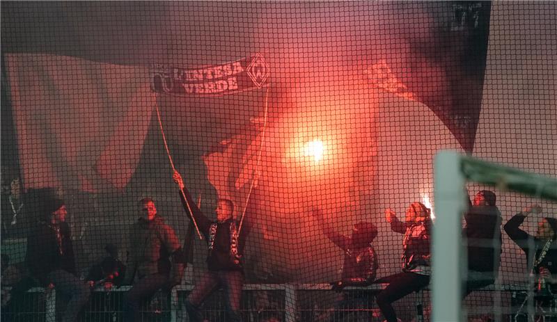 Bremer Fans brennen Pyrotechnik auf der Tribüne ab. Foto: Axel Heimken/dpa