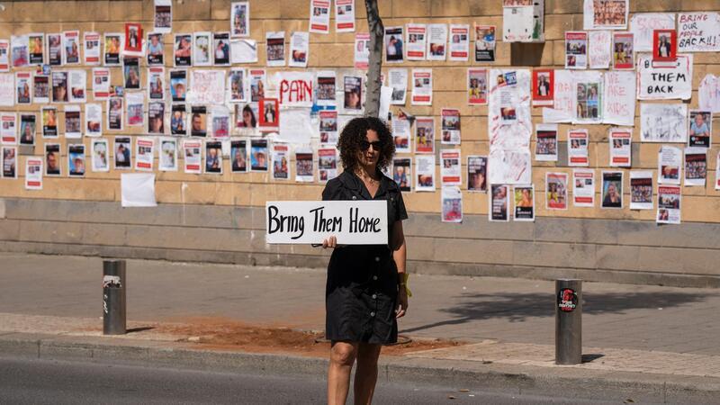WHO rechnet Freitag mit Grenzöffnung in Rafah „Bringt sie nacht Hause“ steht auf dem Schild dieser Frau, die in Tel Aviv vor einer Wand mit den Fotos von Israelis steht, die von der Hamas im Gazastreifen gefangen gehalten werden.