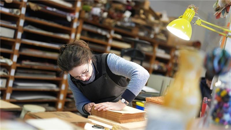Buchbinderin Moiken Petong restauriert in der Werkstatt der Buchbinderei Fritz Castagne ein altes Buch.