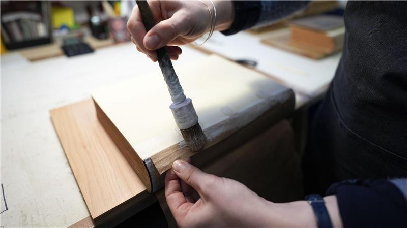 Älteste Buchbinderei gibt gedruckten Schätzen neuen Glanz Buchbinderin Moiken Petong restauriert in der Werkstatt der Buchbinderei Fritz Castagne ein altes Buch.