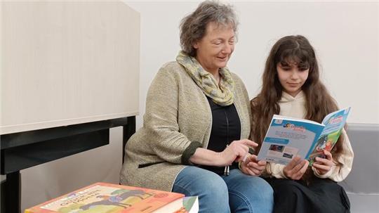 Bücher entdecken und gemeinsam üben: Lesepatin Kirsten Stahl bei ihrer Lesezeit mit Reham im Bildungscampus Riensförde.