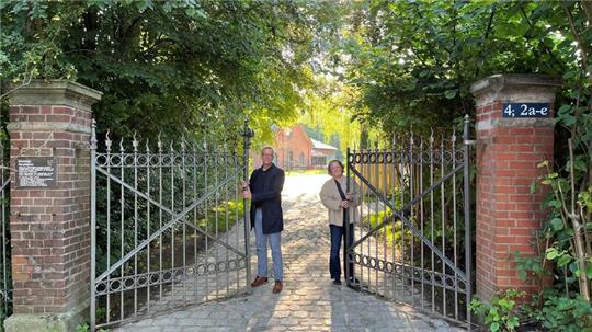 Bürgermeister Knut Willenbockel und die Burginsel-Projektleiterin Gunda Kiefaber öffnen das Tor zum Horneburger Schloss und zum Handwerksmuseum. Die Straße des Guts am Marschdamm wurde erneuert.