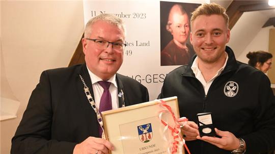 Bürgermeister Matthias Riel (links) überreicht dem Vorsitzenden des TuS Jork, Julian Hamstra, den Bürgerpreis der Gemeinde Jork.