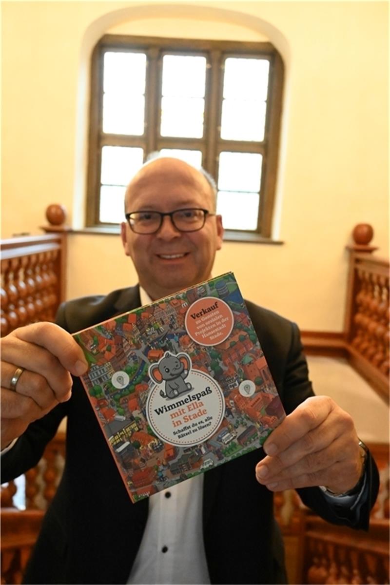 Bürgermeister Sönke Hartlef hält das erste Stader Wimmelbuch (12,50 Euro) in seinen Händen.