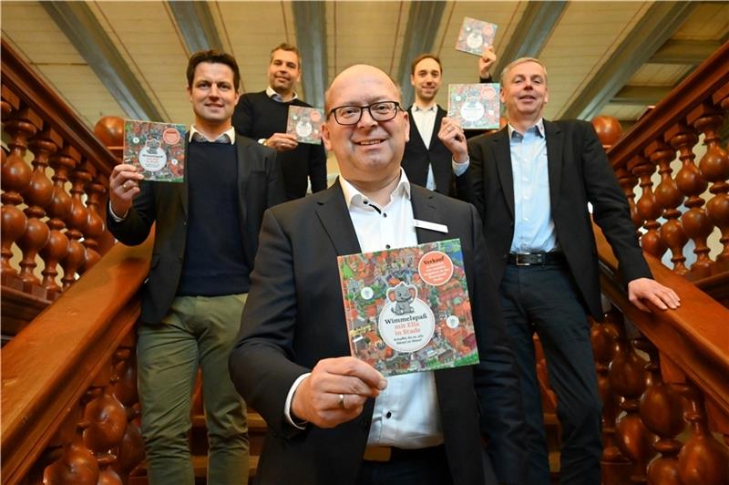 Bürgermeister Sönke Hartlef hält das erste Stader Wimmelbuch (12,50 Euro) in seinen Händen – gemeinsam mit Sponsoren. Foto: Vasel