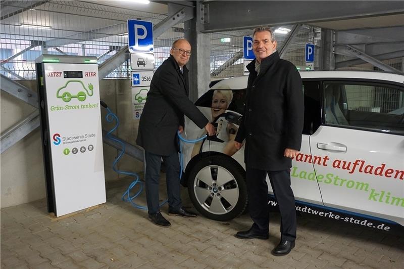 Bürgermeister Sönke Hartlef (links) und Stadtwerke-Chef Christoph Born nehmen die Ladesäulen für Elektrofahrzeuge im neuen Parkhaus Wallstraße in Betrieb.