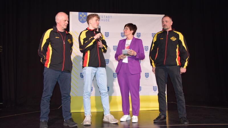 Bürgermeisterin Katja Oldenburg-Schmidt zwischen Weltmeistern: Tjalf Uhlmann (2. v. links) und sein Vater Jens sind jeweils in ihren Altersklassen Weltmeister im Kickboxen des Verbandes WKU. Volker Schubert (links) gewann bei den Weltmeisterschaften in Kanada die Bronzemedaille.