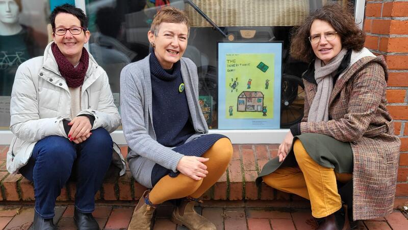 Bullen-Projektleiterin Melanie Hainke (von rechts), Geschäftsinhaberin Sylvia Tiedemann und Susi Milewski vom Buxtehude Museum vor einem der neu gestalteten Buchcover.