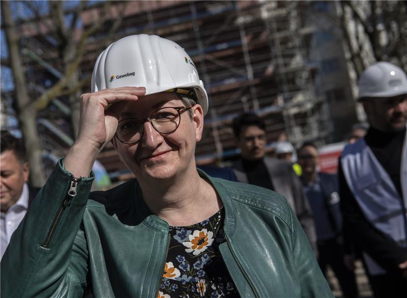 Bundesbauministerin Klara Geywitz (SPD) trägt bei einem Baustellenrundgang einen Bauhelm. Foto: Paul Zinken/dpa