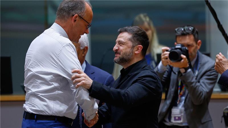 Bundeskanzler Friedrich Merz (l) unterhält sich mit dem ukrainischen Präsidenten Wolodymyr Selenskyj während einer Diskussionsrunde auf dem EU-Gipfel in Brüssel.