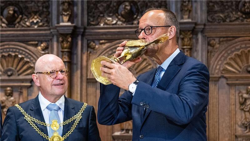 Bilder des Tages Bundeskanzler Friedrich Merz trinkt bei seinem Antrittsbesuch in Nordrhein-Westfalen aus dem goldenen Hahn der Stadt Münster.