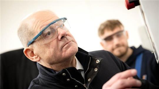 Bundeskanzler Olaf Scholz (SPD, l.), Spitzenkandidat seiner Partei für die Bundestagswahl, hat sich bei einem Besuch der Lloyd Werft in Bremerhaven auch die Ausbildungswerkstatt angesehen.