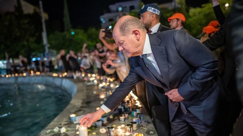 Bundeskanzler Olaf Scholz (SPD) steht bei seinem Solidaritätsbesuch in Israel mit einer Kerze am Dizengoff Square im Zentrum von Tel Aviv.