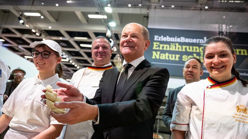Teigzopf und Dialog: Der Kanzler auf der Grünen Woche Bundeskanzler Olaf Scholz mit Hefezopf beim Besuch der Schaubäckerei auf der Grünen Woche.