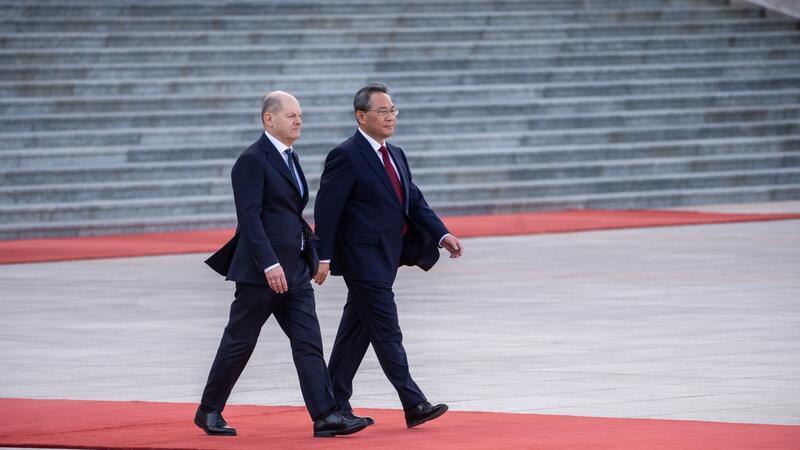 Bundeskanzler Olaf Scholz wird von Ministrpräsident Li Qiang (r) mit militärischen Ehren vor der Großen Halle des Volkes empfangen.