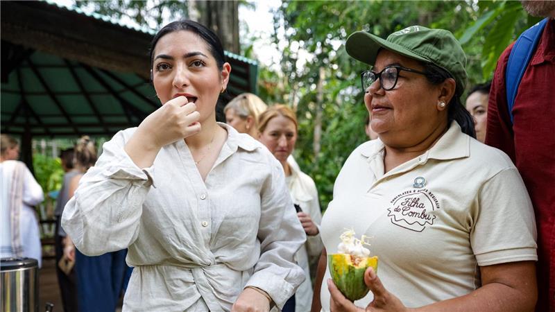 Bundesministerin Radovan (l) verkostet Kakaofrucht.