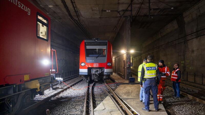Bundespolizisten und Bahnarbeiter stehen in den Morgenstunden an der entgleisten S-Bahn im Tunnel hinter der Haltestelle Isartor.