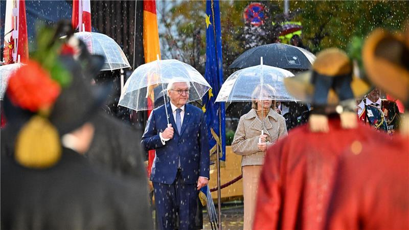 Bundespräsident Frank-Walter Steinmeier und seine Ehefrau Elke Büdenbender nehmen im strömenden Regen am landesüblichen Empfang durch die Tiroler Schützenkompanie teil.