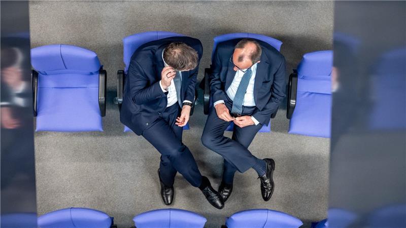 Bundestag - Sondersitzung zur Grundgesetzänderung: Lars Klingbeil (l), SPD Fraktionschef und Bundesvorsitzender, spricht mit Friedrich Merz, CDU/CSU Fraktionsvorsitzender und CDU Bundesvorsitzender.