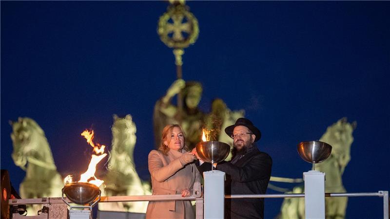 Bundestagspräsidentin Julia Klöckner (CDU) und Rabbiner Yehudi Teichtal entzünden am Brandenburger Tor während einer festlichen Zeremonie die Lichter am Chanukka-Leuchter mittels einer Fackel.