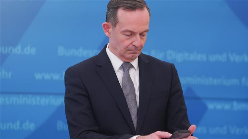 Bundesverkehrsminister Volker Wissing (FDP) blickt bei einer Pressekonferenz im März 2022 auf sein Smartphone.