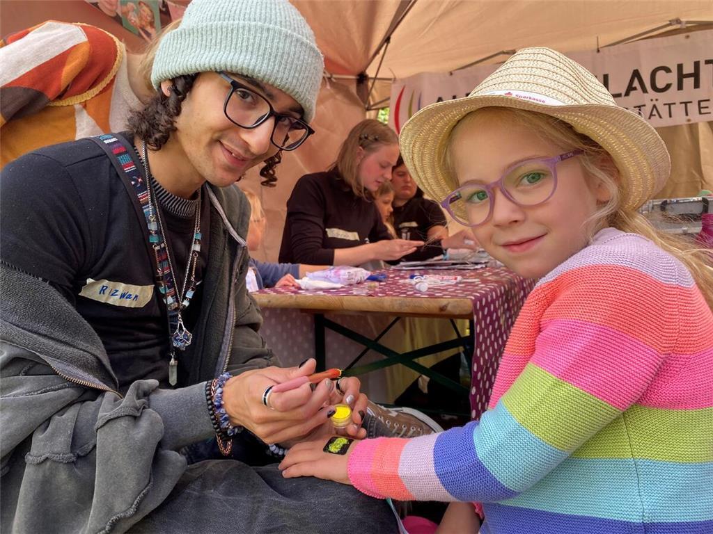 Bunte Meile für Kinder: Lola bekommt ein Glitzertattoo auf die Hand.