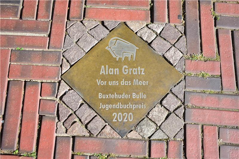 Messingplatte in einem Weg zu Ehren von Jugendbuchpreissieger Alan Gratz.