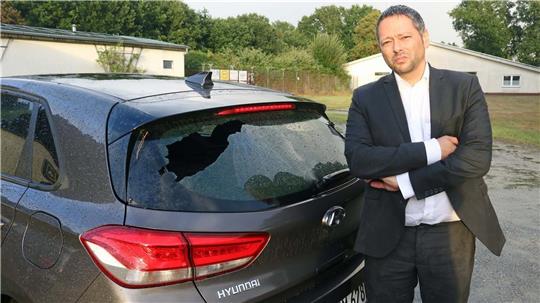 CDU-Landtagskandidat Dr. Denis Ugurcu vor der eingeschlagenen Heckscheibe seines Wagens. Foto: Baur