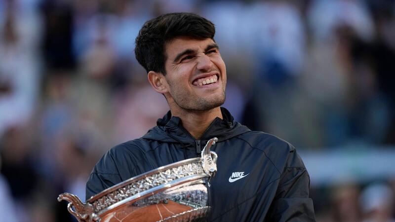 Carlos Alcaraz feiert mit der Trophäe nach seinem Sieg.