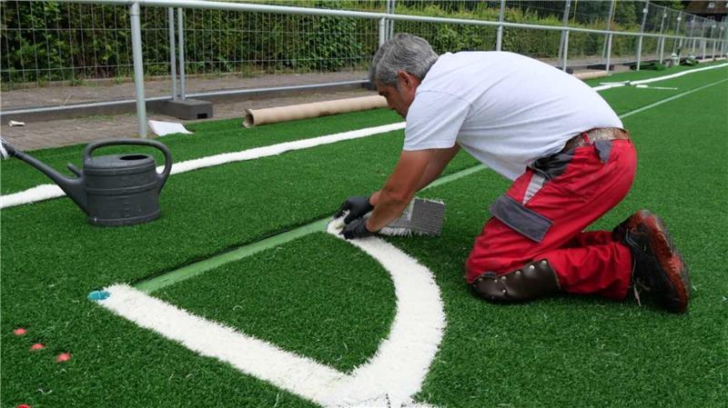 Carlos Barros, Mitarbeiter der Firma Polytan, sorgt mit präzisen Linien für Orientierung auf dem Spielfeld.