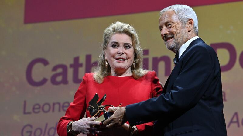Catherine Deneuve wird 80 Catherine Deneuve wird 2022 in Venedig von Festivalpräsident Roberto Cicutto geehrt.