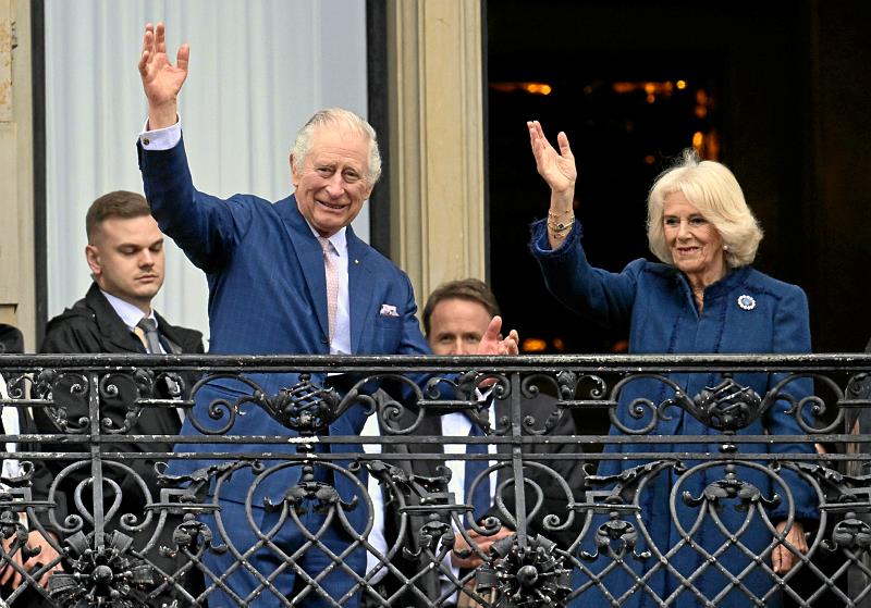 Charles und Camilla winken den zahlreichen Royal-Fans vom Rathausmarkt zu. Foto: dpa