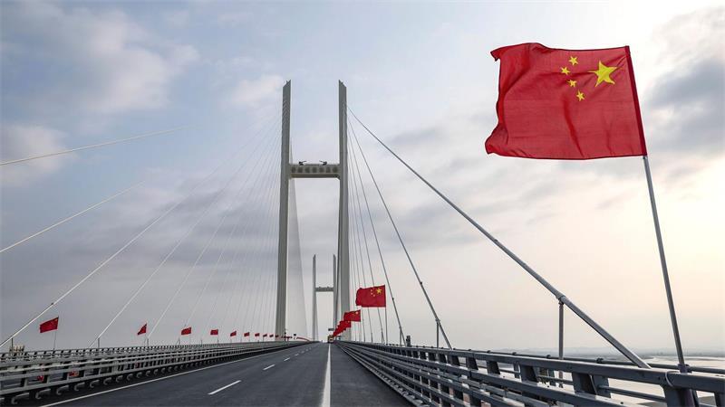 Chinesische Fahnen wehen auf einer Brücke.