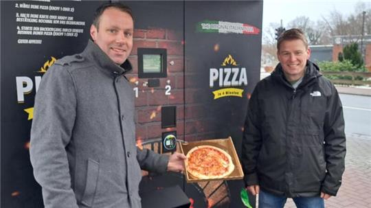 Christian Schwabe (links) und Thorsten Heitland haben einen Pizza-Automaten an der Bahnhofstraße in Stubben aufgestellt.