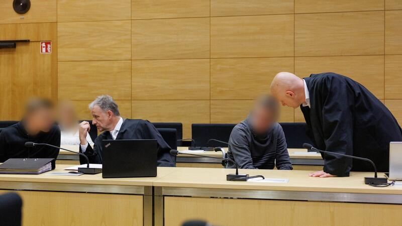 Christian Thüner (2.v.l) und Jerrit Schöll (r), die Verteidiger der Angeklagten, sprechen mit ihren Mandanten in einem Saal des Landgericht Bielefeld zum Auftakt im Prozess um ein illegales Motorradrennen mit Todesfolge.