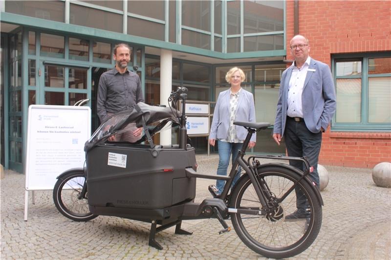 Christian Ückert vom Verein „Stade fährt Rad“ (links), Bürgermeister Sönke Hartlef und die Klimaschutzbeauftragte Siegrun van Bernem während der E-Lastenrad-Übergabe vor dem Rathaus . Foto: Stadt Stade