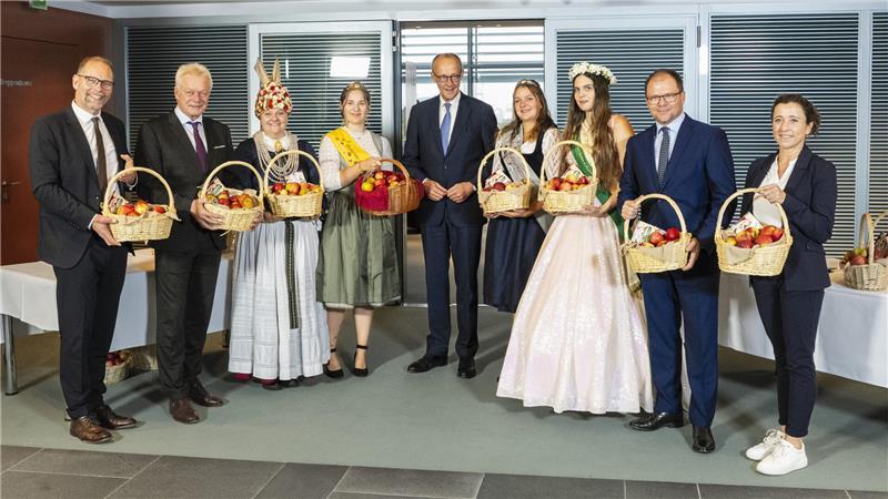 Christian Weseloh (GF Raiffeisen/BVEO), Alois Rainer (Bundesminister für Ernährung und Landwirtschaft), Ella Maxim Weilert (Blütenkönigin aus dem Alten Land), Bundeskanzler Friedrich Merz, Emelie Witzigmann (Bodensee-Apfelkönigin), Lara Baur (Bodensee-Apfelprinzessin), Alida-Nadine Kühne (Blütenkönigin für Sachsen und Sachsen-Anhalt), Carsten Schneider (Bundesminister für Umwelt, Naturschutz und Reaktorsicherheit), Suse-Katrin Jamrath (stv. GF BVEO)